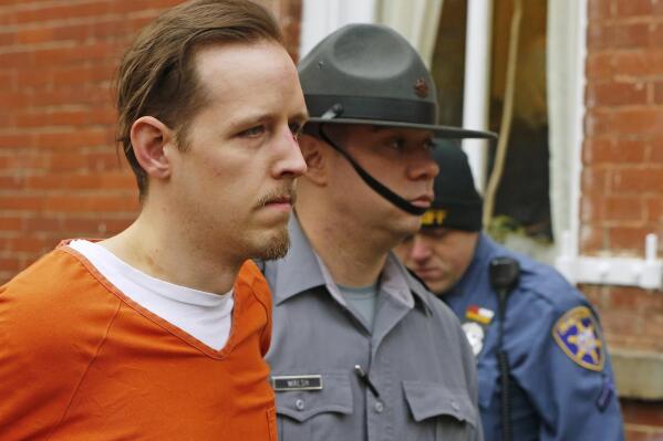 FILE – Eric Frein, left, is escorted out by police after his arraignment at the Pike County Courthouse on Oct. 31, 2014, in Milford, Pa. The parents of Frein, a gunman who killed a Pennsylvania state trooper and permanently disabled another eight years ago in an ambush of a police barracks have settled a lawsuit that accused them of partial responsibility for the attack. A Lackawanna County judge was to hear arguments on the motion Oct. 31, 2022, but court documents indicate that he was advised that the case had been settled, the Wilkes-Barre Citizens' Voice reported. (AP Photo/Rich Schultz, File)