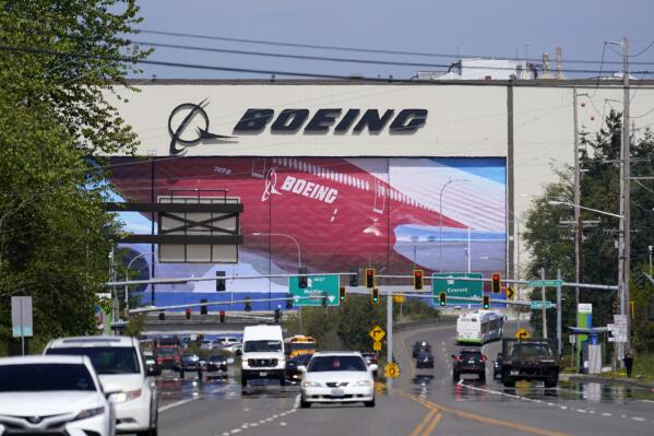 FILE - Traffic drives in view of a Boeing Co. production plant, where images of jets decorate the hangar doors on April 23, 2021, in Everett, Wash. Roughly 2,500 Boeing workers are expected to go on strike the following month at three plants in the St. Louis area after they voted Sunday, July 24, 2022, to reject a contract offer from the plane maker. (AP Photo/Elaine Thompson, File)