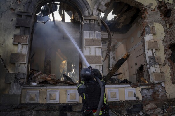 Firefighters put out the fire a railway station after Russians hit in Kostiantynivka, Donetsk region, Ukraine, Sunday, Feb. 25, 2024. A woman was wounded and a railway station, shops and residential houses were badly damaged amid heavy bombing. (AP Photo/Alex Babenko)