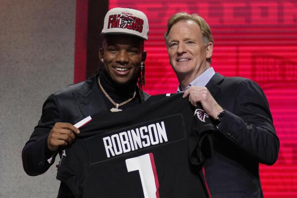 Texas running back Bijan Robinson, left, poses with NFL Commissioner Roger Goodell after being chosen by the Atlanta Falcons with the eighth overall pick during the first round of the NFL football draft, Thursday, April 27, 2023, in Kansas City, Mo. (AP Photo/Jeff Roberson)