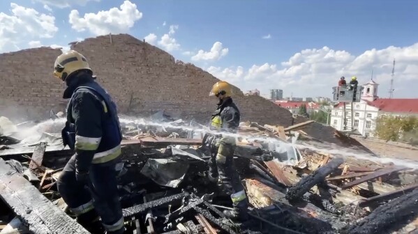 In this photo taken from video provided by the Ukrainian Emergency Service, firefighters work on the roof of the Taras Shevchenko Chernihiv Regional Academic Music and Drama Theatre damaged by Russian attack in Chernihiv, Ukraine, Saturday, Aug. 19, 2023. (Ukrainian Emergency Service via AP)