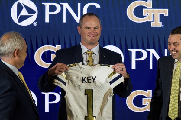 FILE - Newly hired Georgia Tech football coach Brent Key holds up a jersey during a news conference, Monday, Dec. 5, 2022, in Atlanta. The arrivals of Key and and Louisville's Jeff Brohm this year mean that nearly half the ACC's coaches have turned over in the past two seasons, compared to the 2021 season when all 14 football coaches returned to the job. (AP Photo/Danny Karnik, File)