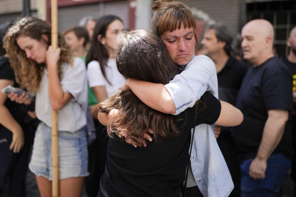 Telam workers hug outside the state-run Telam news agency in Buenos Aires, Argentina, Monday, March 4, 2024. Télam was inactive on Monday and its employees were unable to enter the facility after President Javier Milei announced its closure on March 1. (AP Photo/Natacha Pisarenko)