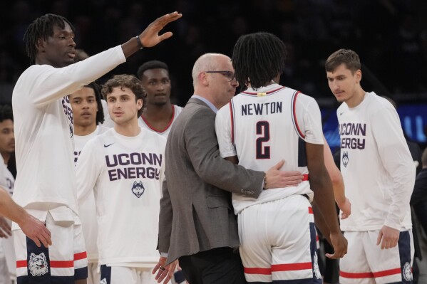 UConn head coach Dan Hurley, center, talks to guard Tristen Newton (2) as he comes to the bench during the first half of an NCAA college basketball game against Marquette in the championship of the Big East Conference tournament, Saturday, March 16, 2024, in New York. (AP Photo/Mary Altaffer)