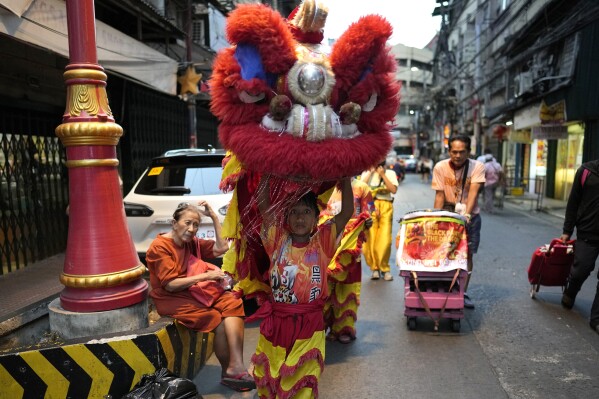 A lion performer walks at Binondo district, said to be the oldest Chinatown in the world, in Manila, Philippines on Tuesday, Feb. 6, 2024. Crowds are flocking to Manila's Chinatown to usher in the Year of the Wood Dragon and experience lively traditional dances on lantern-lit streets with food, lucky charms and prayers for good fortune. (AP Photo/Aaron Favila)