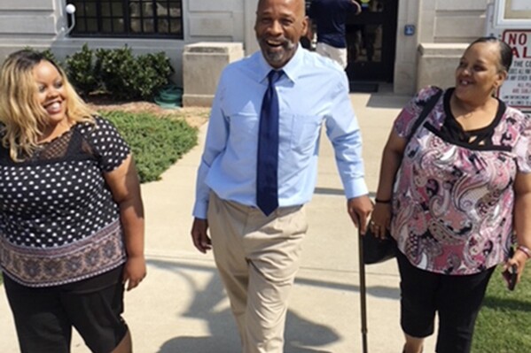 FILE - This photo provided by the Innocence Project shows Perry Lott, center, smiling as he leaves court in Oklahoma City, July 9, 2018, with his daughter Candace Brown, left, and Antoinette Brown, who was his fiancé at the time he was arrested, after being freed from prison when the Innocence Project presented DNA evidence it says excluded him from the crime. An Oklahoma judge on Tuesday, Oct. 10, 2023, exonerated Lott, who spent 30 years in prison for a 1987 rape and burglary, after post-conviction DNA testing from a rape kit showed he did not commit the crime. (Karen Thompson/Innocence Project via AP, File)