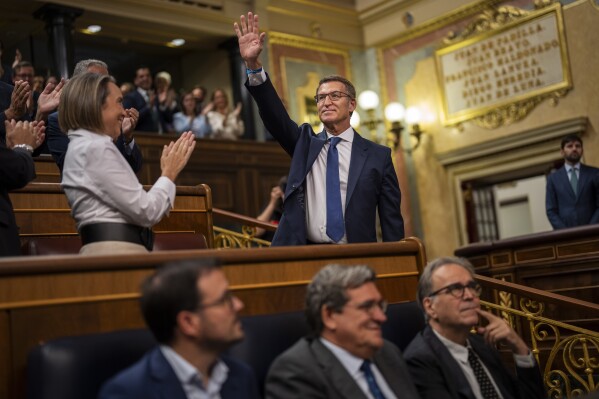 El líder del grupo conservador español Partido Popular, Alberto Núñez Feijóo, saluda a su llegada al Congreso de los Diputados en Madrid, España, el martes 26 de septiembre de 2023. El líder del principal partido conservador español tenía previsto intentar convencer el martes a la cámara baja del parlamento de que le dejen formar el próximo gobierno del país, antes de dos rondas de votaciones esta semana en el Congreso de los Diputados, que se espera que pierda. (AP Foto/Bernat Armangué)