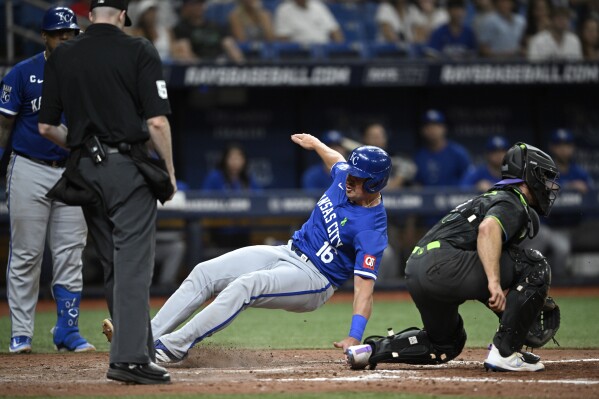Kansas City Royals' Hunter Renfroe (16) scores on a sacrifice fly by Vinnie Pasquantino, as Tampa Bay Rays catcher Ben Rortvedt, right, waits for the throw during the 10th inning of a baseball game Saturday, May 25, 2024, in St. Petersburg, Fla. (AP Photo/Phelan M. Ebenhack)