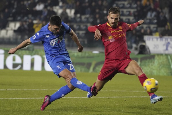 Empoli's Nicolo Cambiaghi, left, kicks the ball past Lecce's Marin Pongracic during the Serie A soccer match between Empoli and Lecce at the Castellani stadium in Empoli, Italy, Monday, Dec. 11, 2023. (Marco Bucco/LaPresse via AP)