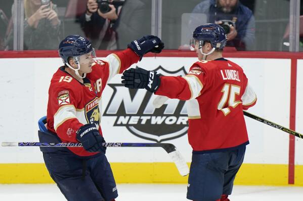 Florida Panthers left wing Matthew Tkachuk (19) and center Anton Lundell (15) celebrate after Tkachuk scored an empy-net goal during the third period of an NHL hockey game against the Ottawa Senators, Saturday, Oct. 29, 2022, in Sunrise, Fla. (AP Photo/Wilfredo Lee)