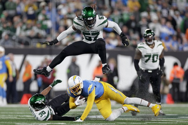 New York Jets linebacker C.J. Mosley (57) leaps over Los Angeles Chargers running back Austin Ekeler (30) as he is tackled by New York Jets cornerback Michael Carter II (30) during the first quarter of an NFL football game, Monday, Nov. 6, 2023, in East Rutherford, N.J. (AP Photo/Adam Hunger)