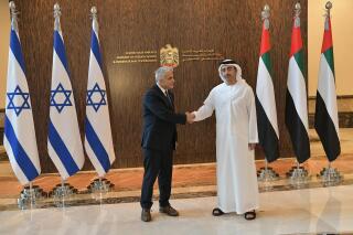 In this photo made available by the Israeli Government Press Office, Israeli Foreign Minister Yair Lapid shakes hands with United Arab Emirates Foreign Minister Sheikh Abdullah bin Zayed al-Nahyan in Abu Dhabi, United Arab Emirates, Tuesday, June 29, 2021. Lapid kicked off the highest-level visit by an Israeli official to the UAE on Tuesday, nine months after the two established relations in a deal brokered by the United States. (Shlomi Amsalem/Government Press Office via AP)