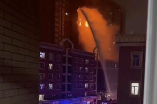 In this image taken from video, firefighters spray water on a fire at a residential building in Urumqi in western China's Xinjiang Uyghur Autonomous Region, Thursday, Nov. 24, 2022. A fire in an apartment building in northwestern China's Xinjiang region has killed several people and injured others, authorities said Friday, in the second major fire accident in the country this week. (AP Photo)