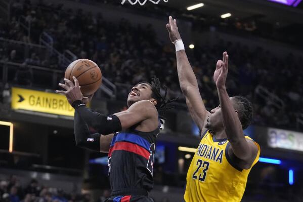 Detroit Pistons guard Jaden Ivey, left, shoots against Indiana Pacers forward Aaron Nesmith during the first half of an NBA basketball game Friday, April 7, 2023, in Indianapolis, (AP Photo/Darron Cummings)
