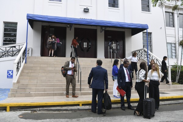 Lawyers and court workers leave the Supreme Court during a recess for the trial of the "Panama Papers" money laundering case in Panama City, Monday, April 8, 2024. (AP Photo/Agustin Herrera)