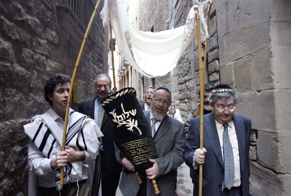 Members of the restored Synagogue of Barcelona carry the holy Torah to their new home in Barcelona, Spain, Sunday, Jan. 22, 2006. Spain's Catalonia suffered region some of the most virulent anti-Semitism of the Middle Ages, and most Jews were driven out nearly a century before all Jews were expelled from the rest of the country in 1492. From then until 20th century Catalan Jews were forgotten people, but these days an increasing amount of respect is being paid to Catalonia's Jewish past. Barcelona odest synagogue, dating from the 9th century, has been restored, and recenty received a gift of a medieval torah, the scrolled parchment bearing the first five books of the Old Testament in Hebrew. (AP Photo/Manu Fernandez)