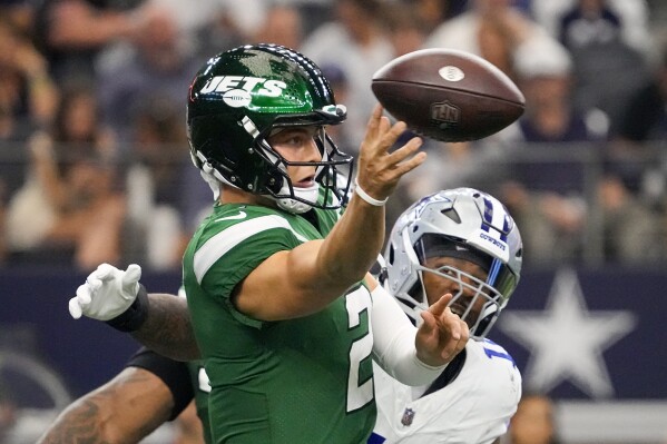 New York Jets quarterback Zach Wilson passes under pressure from Dallas Cowboys linebacker Micah Parsons during the first half of an NFL football game in Arlington, Texas, Sunday, Aug. 17, 2023. (AP Photo/Sam Hodde)