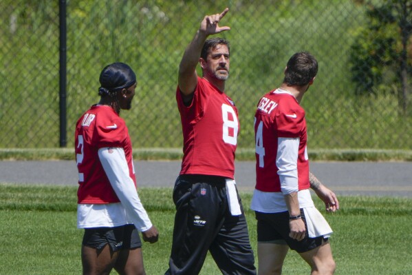 New York Jets quarterback Aaron Rodgers (8) gestures to a teammate during a practice at the NFL football team's training facility in Florham Park, N.J., Tuesday, May 21, 2024. (AP Photo/Seth Wenig)