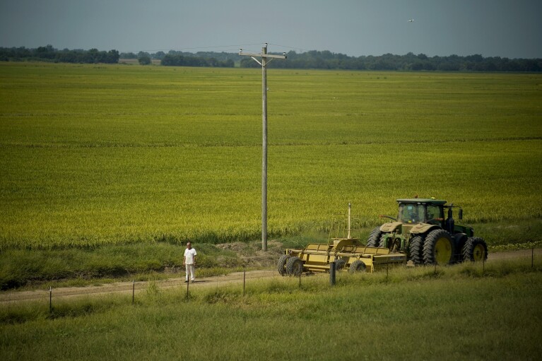 Prisoner Christopher Terrell stands near a tractor at the Cummins Unit of Arkansas' Department of Corrections Friday, Aug. 18, 2023, in Gould, Ark. (AP Photo/John Locher)