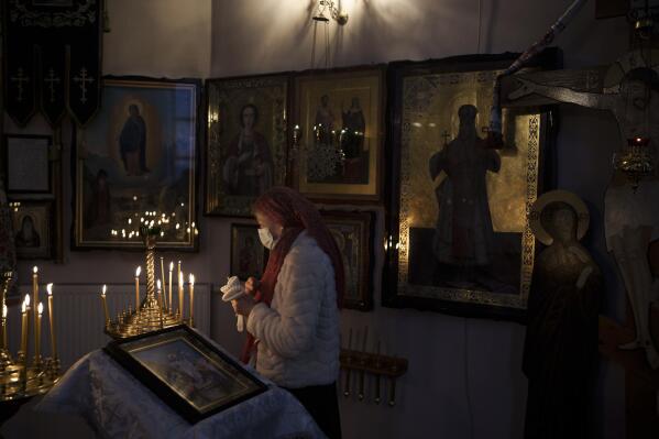 A woman attends a Christmas mass at an Orthodox Church in Bobrytsia, outskirts of Kyiv, Ukraine, Sunday, Dec. 25, 2022. Sunday began with the sound of sirens, but that didn't prevent people from gathering in the church and attend for the first time a Christmas mass on Dec. 25. (AP Photo/Felipe Dana)