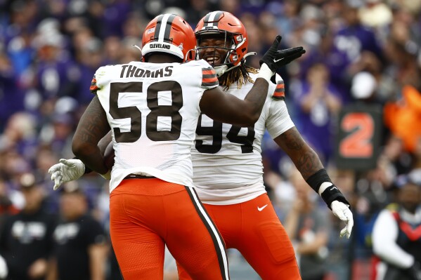 FILE - Cleveland Browns defensive end Isaiah Thomas (58) celebrates his fumble recovery with Alex Wright during the fourth quarter of an NFL football game on Oct. 23, 2022, in Baltimore. Second-year ends Wright and Thomas could miss significant time for the Browns with knee injuries. Coach Kevin Stefanski revealed both injuries while providing few other details or a timetable for recovery before practice on Monday, Aug. 7, 2023. (AP Photo/Rich Schultz, File)