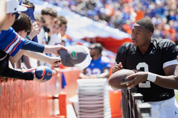 Florida's injured quarterback DJ Lagway, (2) signs autographs during the Orange and Blue spring NCAA college football game, Saturday, April 12, 2025, in Gainesville, Fla. (Willie J. Allen Jr./Orlando Sentinel via AP)