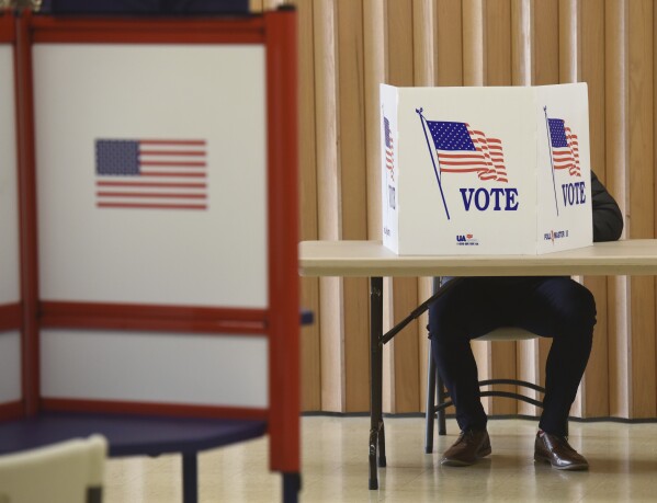 FILE - A resident votes at the Zion St. Joe United Church of Christ on Election Day, Nov. 3, 2020, in St. Joseph, Mich. Stefanie Lambert, a Michigan attorney involved in multiple efforts around the country to overturn the 2020 election in support of former President Donald Trump, was charged Thursday, Aug. 3, 2023, in connection with accessing and tampering with voting machines in Michigan, according to court records. (Don Campbell/The Herald-Palladium via AP, File)