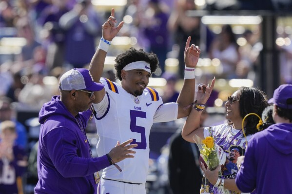 FILE - LSU quarterback Jayden Daniels (5) celebrates with his parents on senior day, for his final home game, before an NCAA college football game against Texas A&M in Baton Rouge, La., Saturday, Nov. 25, 2023. Daniels is a possible first round pick in the NFL Draft.(AP Photo/Gerald Herbert, File)