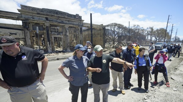 FILE - Hawaii Gov. Josh Green, center, points to damage as he speaks with Federal Emergency Management Agency Administrator Deanne Criswell during a tour of wildfire damage, Saturday, Aug. 12, 2023, in Lahaina, Hawaii. On Friday, Aug. 18, FEMA said it approved $2.3 million in assistance to roughly 1,300 households in Maui so far, as the federal government tries to help survivors of the devastating wildfires. (AP Photo/Rick Bowmer, File)