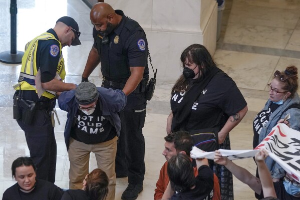 U.S. Capitol Police officers detain demonstrators protesting inside the Cannon House Office Building on Capitol Hill in Washington, Wednesday, Oct. 18, 2023. (AP Photo/Mariam Zuhaib)