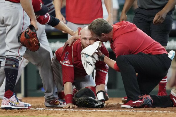Los Angeles Angels' Jonathan Lucroy, center, is helped by medical personnel after colliding with Houston Astros' Jake Marisnick during the eighth inning of a baseball game Sunday, July 7, 2019, in Houston. (AP Photo/David J. Phillip)