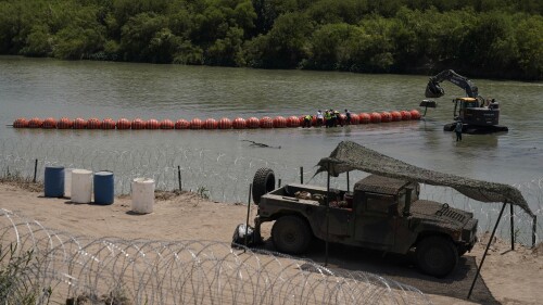 Workers assemble large buoys to be used as a border barrier along the banks of the Rio Grande in Eagle Pass, Texas, Tuesday, July 11, 2023. Texas Republican Gov. Greg Abbott has escalated measures to keep migrants from entering the U.S. He's pushing legal boundaries along the border with Mexico to install razor wire, deploy massive buoys on the Rio Grande and bulldozing border islands in the river. (AP Photo/Eric Gay)