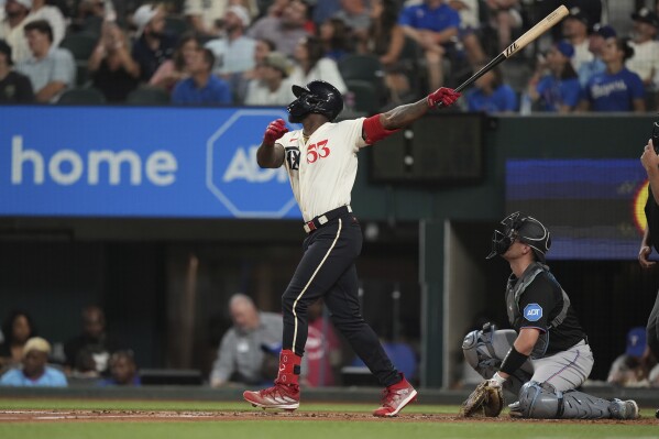 Texas Rangers' Adolis Garcia (53) and Miami Marlins catcher Nick Fortes watch Garcia's solo home run during the third inning of a baseball game in Arlington, Texas, Friday, Aug. 4, 2023. (AP Photo/LM Otero)