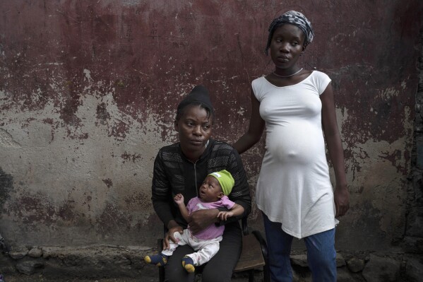 FILE - Januelle Datka, her baby girl Princess and her 15-year-old daughter Titti, pose for a photo at a makeshift shelter in Jean-Kere Almicar's front yard, in Port-au-Prince, Haiti, June 4, 2023. Both mother and daughter said they were raped by gang members and that both became pregnant. (AP Photo/Ariana Cubillos, File)