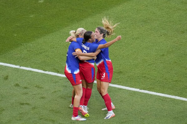 Mallory Swanson, of the United States, center, celebrates with teammates after scoring her side's first goal during the women's soccer gold medal match between Brazil and the United States at the Parc des Princes during the 2024 Summer Olympics, Saturday, Aug. 10, 2024, in Paris, France. (AP Photo/Vadim Ghirda)