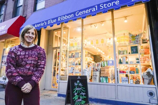 Ann Cantrell, owner of Annie's Blue Ribbon General Store poses for a photo outside her store, Wednesday, Dec. 15, 2021, in the Brooklyn borough of New York. Cantrell has owned the store in Brooklyn for 14 years. She said social media promotions to reach out to customers during the pandemic are still boosting sales, including a video of new items each Friday. (AP Photo/Mary Altaffer)