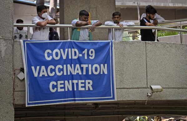 People watch others arrive to receive the COVID-19 vaccine at a government-run hospital in New Delhi, India, Tuesday, Sept. 21, 2021. Travelers and authorities from India and many African countries are furious — and confused — about Britain's new COVID-19 travel rules, calling them discriminatory, as experts warn the measures could fuel misinformation about vaccines in countries in some of the world's least vaccinated countries. (AP Photo/Manish Swarup)