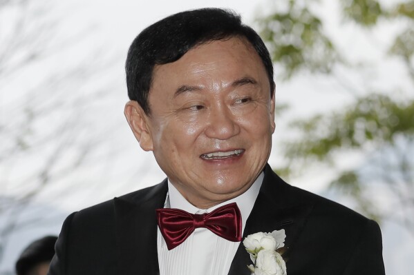 FILE - Former Thai Prime Minister Thaksin Shinawatra welcomes his guests for the wedding of his youngest daughter Paetongtarn 