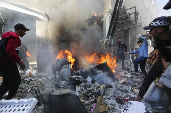 Palestinians look for survivors after an Israeli strike on Rafah, Gaza Strip, Friday, Nov. 17, 2023. (AP Photo/Hatem Ali)