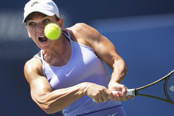FILE - Simona Halep, of Romania, returns the ball to Beatriz Haddad Maia, of Brazil, during the final of the National Bank Open tennis tournament in Toronto, Aug. 14, 2022. Halep returned to professional tennis after successfully reducing a doping suspension on appeal, playing her first match in about 1 1/2 years Tuesday, March 19 — a 1-6, 6-4, 6-3 loss to Paula Badosa at the Miami Open. (Nathan Denette/The Canadian Press via AP, File)