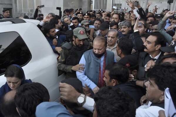 Security personnels clear way for Pakistan's former Prime Minister Nawaz Sharif, center, leaves after appearing in a court in Islamabad, Pakistan, Thursday, Oct. 26, 2023. A federal court in Pakistan's capital restored the appeals of the country's former Prime Minister Sharif against his 2018 conviction in graft cases, less than a week after this Islamic nation's three-time former premier returned home. (AP Photo/W.K. Yousafzai)