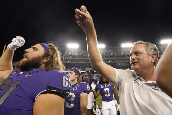 TCU head coach Sonny Dykes, right, holds up his hand during the school song with offensive lineman Riley Self (61) and other teammates on the field after an NCAA college football game against Tarleton State in Fort Worth, Texas, Saturday, Sept. 10, 2022. (AP Photo/LM Otero)