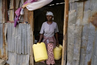 Joyce Ngui heads to fetch groundwater in Athi River, Machakos county, Kenya, Tuesday, Oct. 17, 2023. “Sometimes, we get to the water vending stations and find that the queue is long and then the water finishes and you have to wait,” Ngui said. “Most of the times you don’t have money to buy even the salty water sold around. So we have no choice but to use the swamp water," she said. (AP Photo/Brian Inganga)