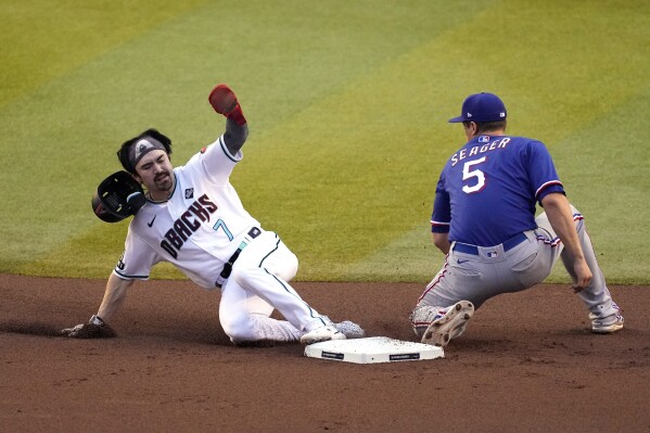 Arizona Diamondbacks' Corbin Carroll (7) steals second base as Texas Rangers shortstop Corey Seager (5) reaches to tag him during the first inning in Game 5 of the baseball World Series Wednesday, Nov. 1, 2023, in Phoenix. (AP Photo/Ross D. Franklin)