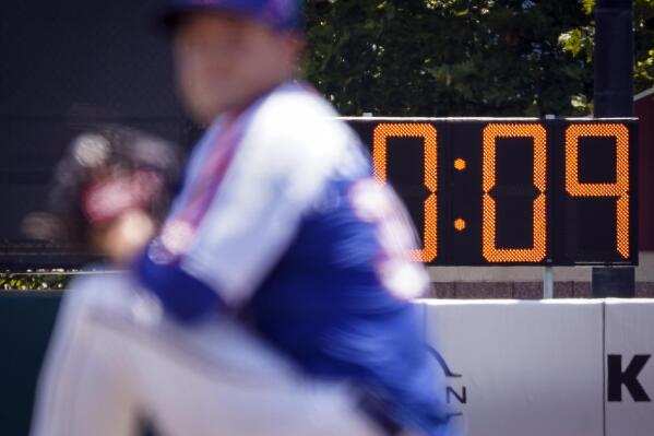 FILE - A pitch clock is deployed to restrict pitcher preparation times during a minor league baseball game between the Brooklyn Cyclones and Greensboro Grasshoppers, on July 13, 2022, in the Coney Island neighborhood of the Brooklyn borough of New York. Opening day will feature three of the biggest changes since 1969: Two infielders will be required to be on either side of second base, base size will increase to 18-inch squares from 15 and a pitch clock will be used. (AP Photo/John Minchillo, File)