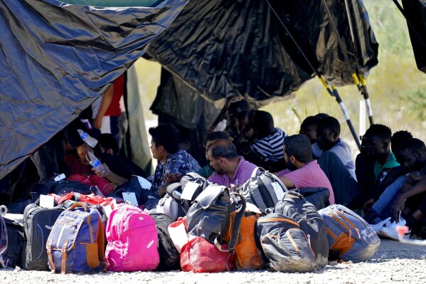 A group of men detained by U.S. Customs and Border Patrol after crossing the border wall in the Tucson Sector of the U.S.-Mexico border, are processed at a makeshift intake center, Tuesday, Aug. 29, 2023, in Organ Pipe Cactus National Monument near Lukeville, Ariz. U.S. Customs and Border Protection reports that the Tucson Sector is the busiest area of the border since 2008 due to smugglers abruptly steering migrants from Africa, Asia and other places through some of the Arizona borderlands' most desolate and dangerous areas. (AP Photo/Matt York)