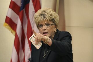 FILE - In this Nov. 6, 2019, file photo, Las Vegas Mayor Carolyn Goodman points toward protesters during the council meeting where the city council was considering a ban on homeless camping in Las Vegas. Nevada officials condemned comments Wednesday, April 22, 2020, by Goodman after she called for casinos and other nonessential businesses to reopen and suggested the city could serve as a test case to measure the impact during the coronavirus pandemic. One local official called her comments "reckless and dangerous." (Bizuayehu Tesfaye/Las Vegas Review-Journal via AP, File)