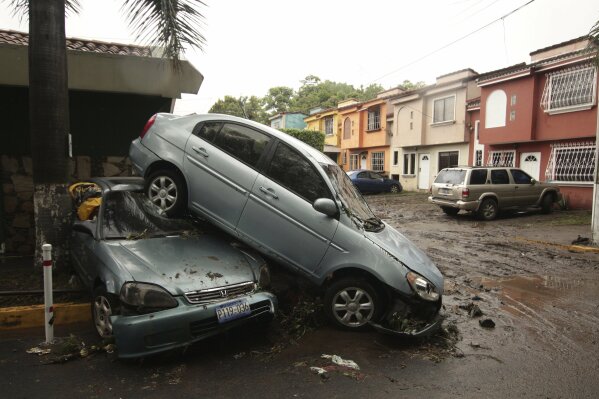 Vehicles stand damaged by an Acelhuate River flash flood at a neighborhood in San Salvador, El Salvador, Sunday, May 31, 2020. According to the Ministry of the Interior, at least seven people died across the country after two days of heavy rains. (AP Photo/Salvador Melendez)