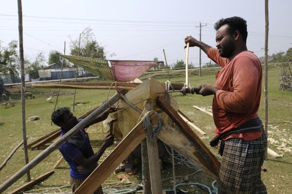 Craftsmen build a fishing boat at Chila Bazar, in Mongla, Bangladesh, March 4, 2022. Mongla is located near the world's largest mangrove forest Sundarbans. The town was once vulnerable to floods and river erosion, but now it has become more resilient with improved infrastructure against high tides and erosion. (AP Photo/Mahmud Hossain Opu)