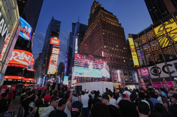 People gather in Times Square to watch a boxing match Friday, May 2, 2025, in New York. (AP Photo/Frank Franklin II)